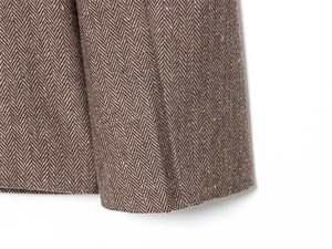 Macro shot of brown herringbone wool fabric texture on high-quality winter blazer