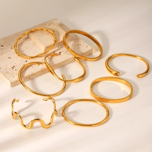 Collection of 18K gold plated stainless steel bangles featuring minimalist wave designs