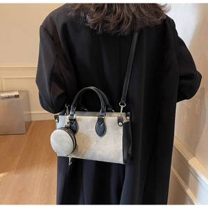 Détail du sac cabas en toile grise avec finitions en cuir noir et petite pochette ronde