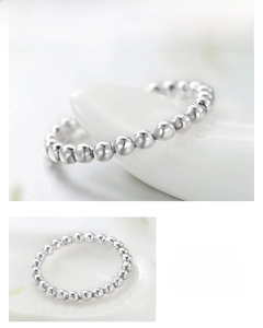 Vue macro d'une bague en perles d'argent S925 minimaliste avec éclat métallique