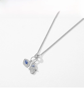 Macro view of S925 silver necklace with Hamsa Hand and blue Evil Eye pendants