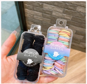Handheld detail of two boxes with high-elasticity colorful kids hair ties for little girls