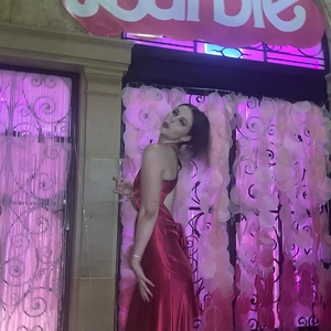 Détail d'une robe longue rouge en satin dos nu avec lacets croisés dans une fête