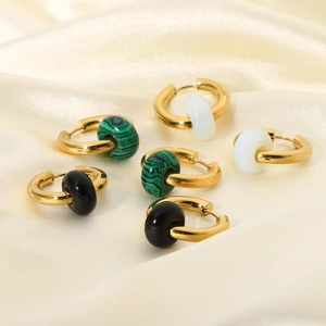Detailed view of gold stainless steel hoop earrings with textured stone charms in three colors