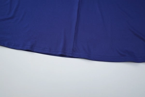 Détail de l'ourlet de robe bleu roi montrant les coutures et le drapé du tissu