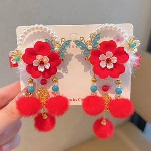 Detail of red Chinese style hair clips with silk tassels, beads, and soft faux fur balls