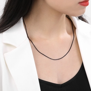 Detail of 1.5mm black stainless steel snake chain necklace worn by a fashion model