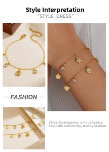 Detail of gold-plated bracelet with flower and heart charms inlaid with rhinestones