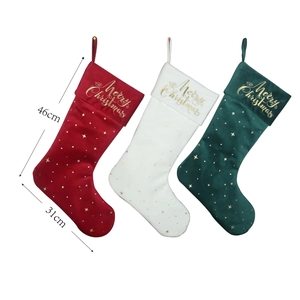 Detailed view of red, white, and green velvet Christmas stockings with gold embroidery