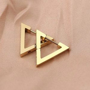 Polished gold triangle geometric hinge earrings in stainless steel on textured fabric