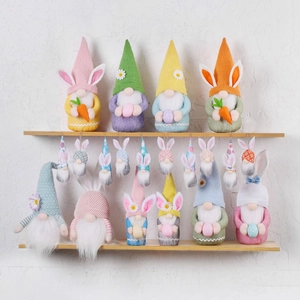 Easter gnomes with bunny ears and carrots arranged on a two-tier wooden display shelf