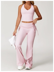 Detail of pink flare yoga pants featuring a folded high waist and side drawstring accents