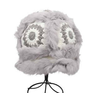 Detail of plush faux fur and knit bucket hat with vintage floral patterns and warm gray trim