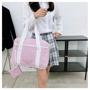 Detailed view of pink JK uniform handbag with heart-shaped transparent window and coin pouch