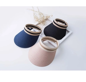 Dettaglio di cappelli da sole in paglia con trama intrecciata e fasce decorative a righe