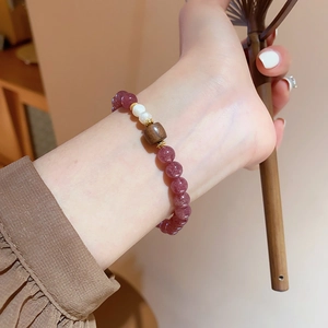 Detailaufnahme des Erdbeerkristall-Armbands mit Süßwasserperlen und Holzperle