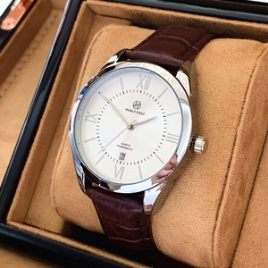 Close-up of a silver quartz watch with white dial and brown leather strap in a gift box