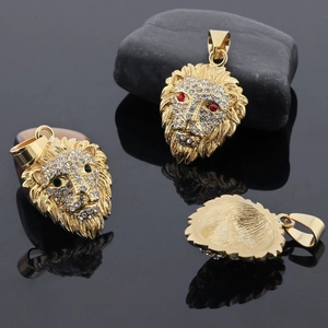 Macro detail of gold plated lion head pendant featuring sparkling crystals and gem eyes