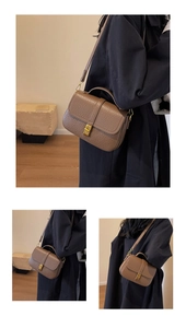 Detail of retro brown litchi grain leather bag with vintage golden square buckle