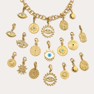 Detailed view of gold evil eye pendants with blue enamel and sparkling rhinestones