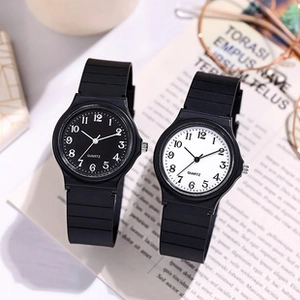 Montres à quartz or rose avec cadrans noirs et blancs posées sur un livre ouvert