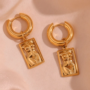 Detailed macro shot of 18K gold plated rectangle pendant earrings with female torso art