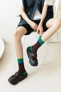 Detail of color-block crew socks in coffee brown with retro green and blue stripes