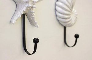 Detalle de ganchos de pared con forma de concha y estrella de mar en resina blanca