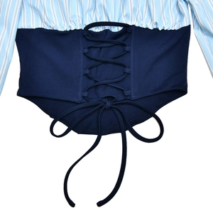 Detail of blue and white striped shirt back featuring criss-cross lacing and bow design