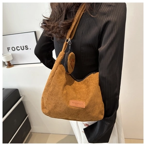 Brown corduroy tote bag detail showing the fashion leather patch and round coin purse