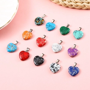 Detailed collection of 20mm heart-shaped natural stone pendants on pink background