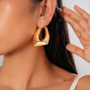 Close-up of a model wearing minimalist 18K gold plated irregular geometric earrings