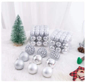 Silver Christmas ball ornaments in shiny, matte, and hollow glitter finishes on plush white