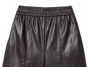 Detailed macro view of the elastic waistband and faux leather texture on high-waist shorts