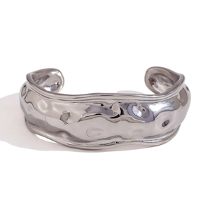 Adjustable silver cuff bracelet with organic molten lava texture on white background