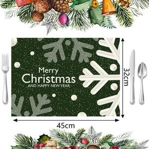 Detalle de mantel individual verde de 45x32cm con copos de nieve y texto Merry Christmas