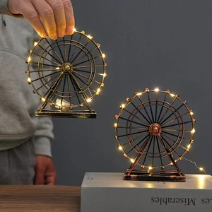 European vintage ferris wheel metal ornament with warm LED lights on books