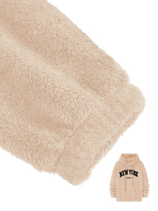 Detail of beige fleece fabric texture and black New York print on hooded sweatshirt