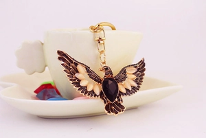 Detail view of a vintage golden eagle keychain featuring black teardrop crystal and rhinestones