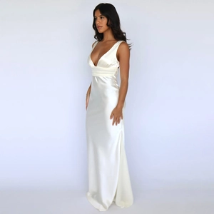 Detail of elegant white silk maxi dress with deep V-neck and draped floor-length skirt