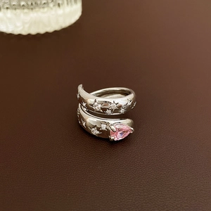 Detailed macro of silver open ring with pink pear-shaped stone and star engravings
