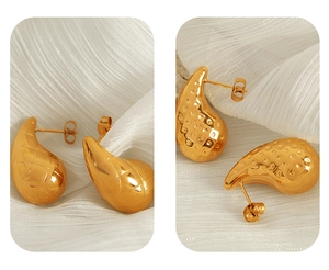 Detailed view of teardrop earrings with textured diamond and dot patterns in gold plating