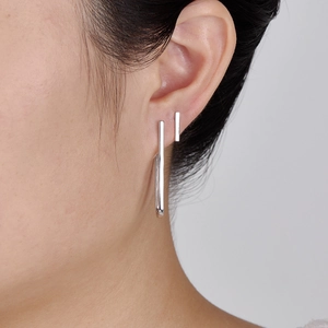 Elegant minimalist silver 925 geometric bar stud earrings worn by a model in a close-up