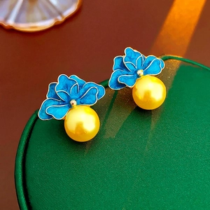 Detail view of vintage French blue enamel flower earrings with golden pearl drops