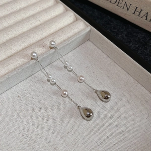 Gros plan détaillé de boucles d'oreilles vintage en argent avec perles dans un écrin beige