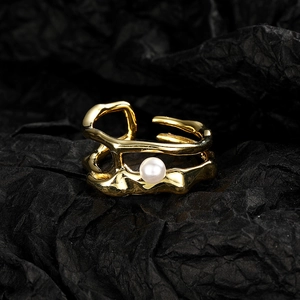 Vintage irregular gold line open ring with central white pearl on dark paper