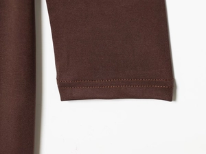 Detail of high-density elastic knit fabric with neat double-needle stitching in brown