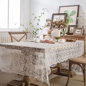 White floral lace tablecloth with embroidery on a wooden table for home decor