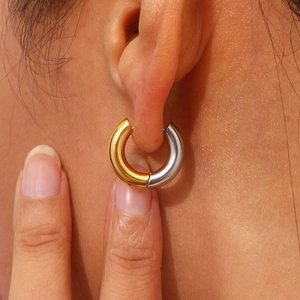 Fashionable two-tone C-shape stainless steel chunky hoop earrings worn on ear