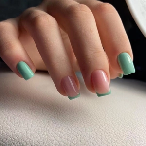 Short square press-on nails in mint green and nude French tip design with glossy finish